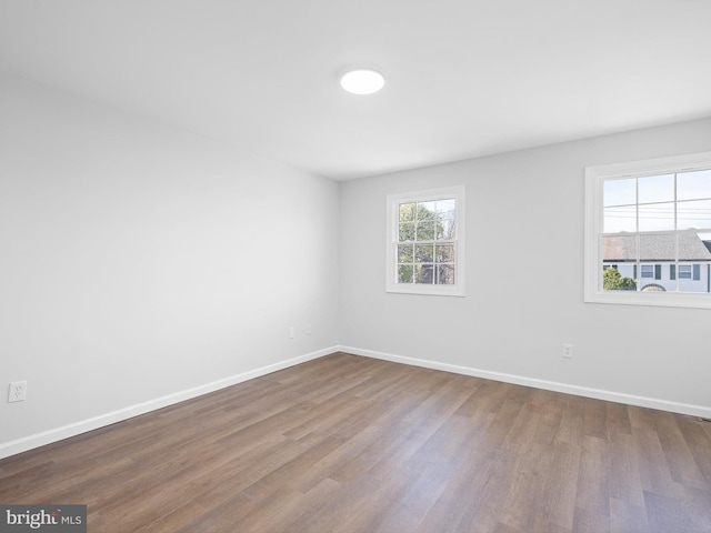 empty room featuring wood finished floors and baseboards