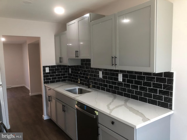 kitchen featuring dishwasher, light stone countertops, a sink, and dark wood-type flooring