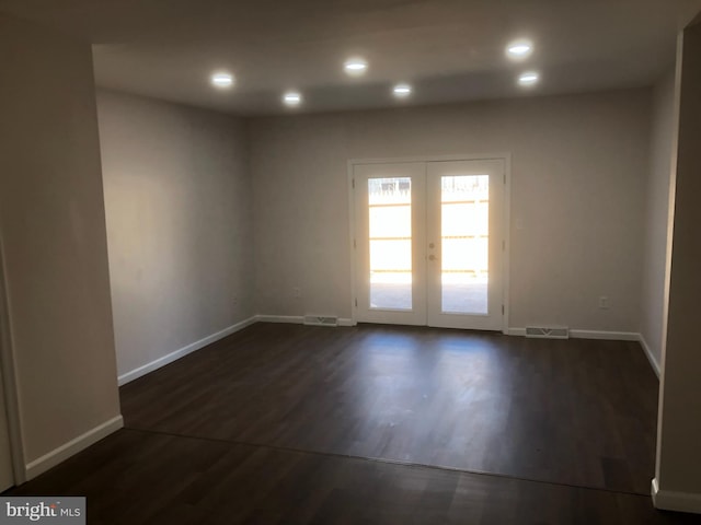 empty room with dark wood-style floors, baseboards, visible vents, and recessed lighting