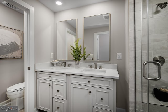 bathroom with toilet, a stall shower, a sink, and visible vents