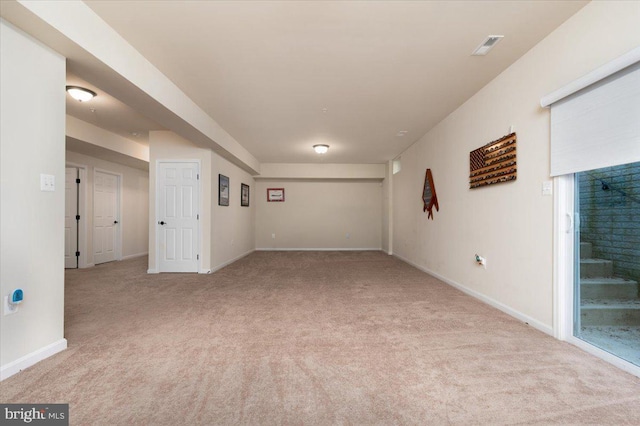 unfurnished room featuring visible vents, light carpet, and baseboards