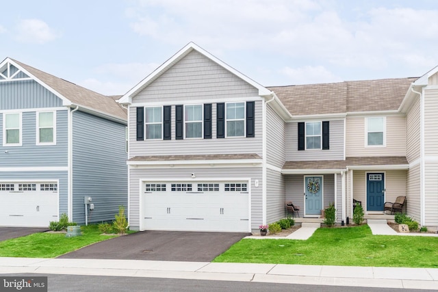view of front of house with an attached garage, a shingled roof, a front yard, and aphalt driveway
