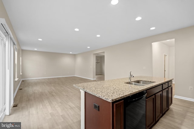 kitchen with baseboards, dishwasher, a sink, light wood-type flooring, and a kitchen island with sink