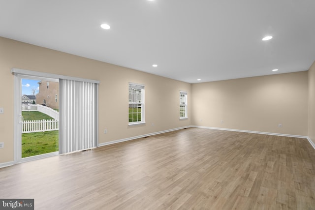 unfurnished living room with recessed lighting, light wood finished floors, and baseboards