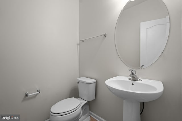 bathroom with toilet and baseboards