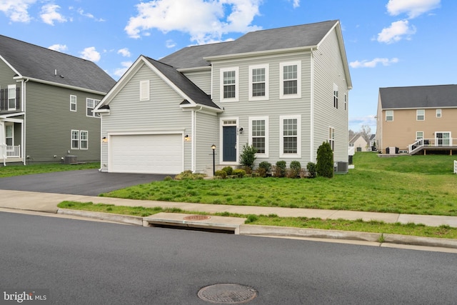 view of front of house with central air condition unit, driveway, and a front yard