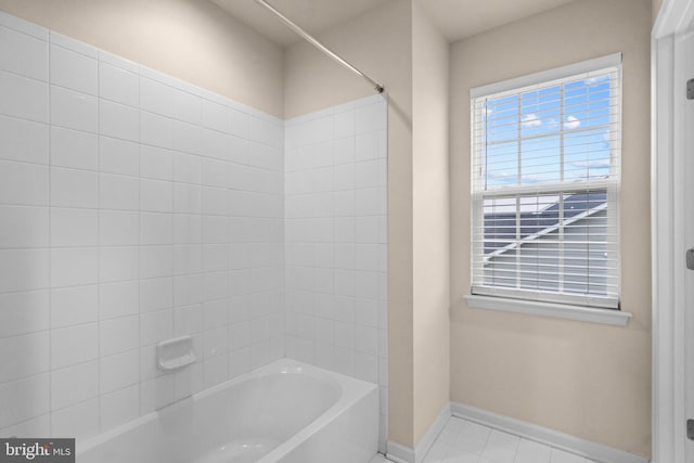 bathroom featuring baseboards, tile patterned flooring, and shower / washtub combination
