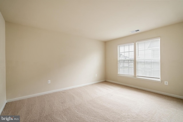 unfurnished room featuring light colored carpet, baseboards, and visible vents