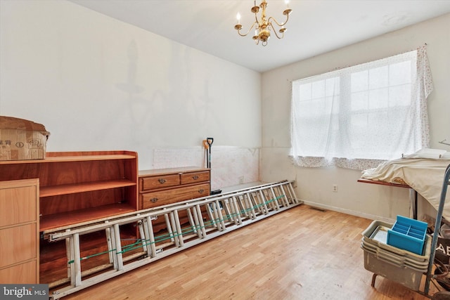 interior space featuring wood finished floors, visible vents, a notable chandelier, and baseboards