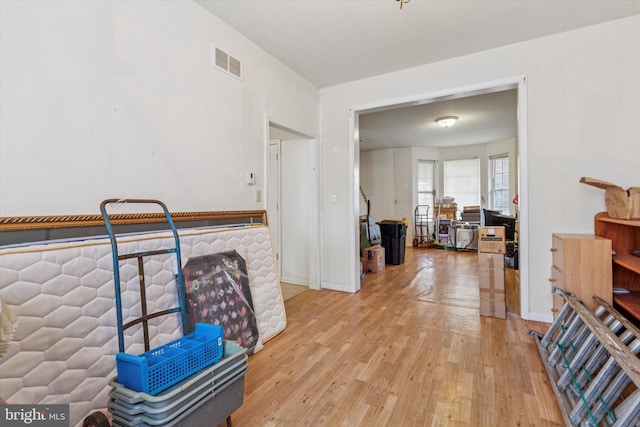 interior space featuring light wood-style floors, visible vents, and baseboards