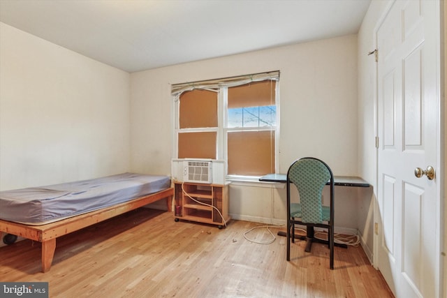 bedroom with baseboards, cooling unit, and wood finished floors