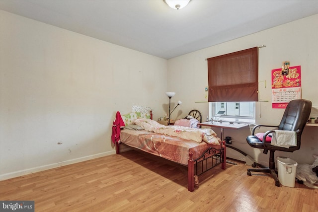 bedroom featuring baseboards and wood finished floors