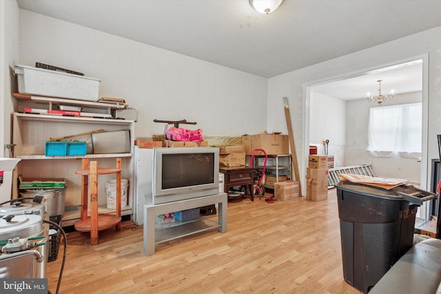rec room featuring a chandelier and wood finished floors
