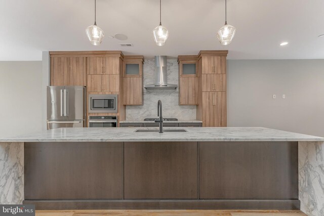 350 Star Tavern Ln, West Chester, PA 19382 - kitchen featuring stainless steel appliances, wall chimney range hood, a sink, light stone countertops, and tasteful backsplash