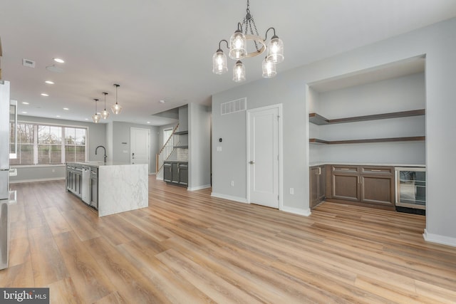 350 Star Tavern Ln, West Chester, PA 19382 - kitchen with baseboards, visible vents, light wood-style floors, a notable chandelier, and beverage cooler