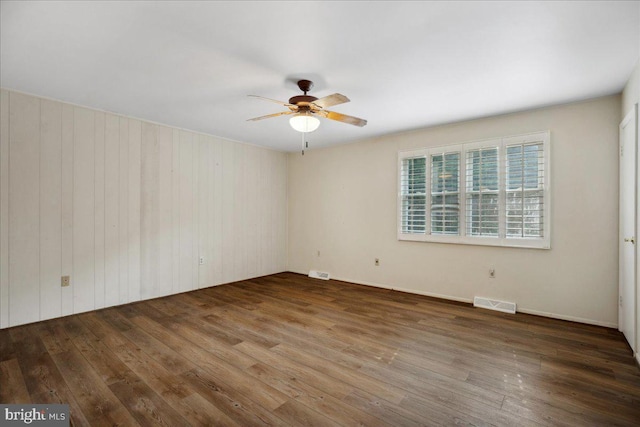 5650 Warren Dr, Huntingtown, MD 20639 - spare room with a ceiling fan, wood walls, wood finished floors, and visible vents