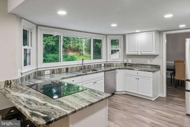 2320 Harpoon Dr, Stafford, VA 22554 - kitchen with black electric stovetop, stainless steel dishwasher, stone counters, light wood-type flooring, and white cabinetry