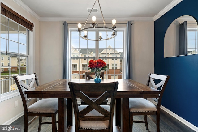 dining room with a chandelier, visible vents, baseboards, and wood finished floors