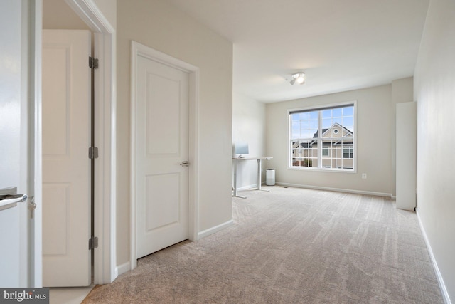hallway with baseboards and carpet