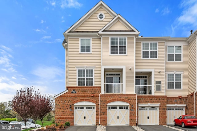townhome / multi-family property featuring a garage, brick siding, and driveway