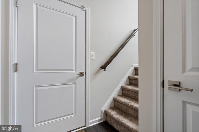 staircase with baseboards and wood finished floors
