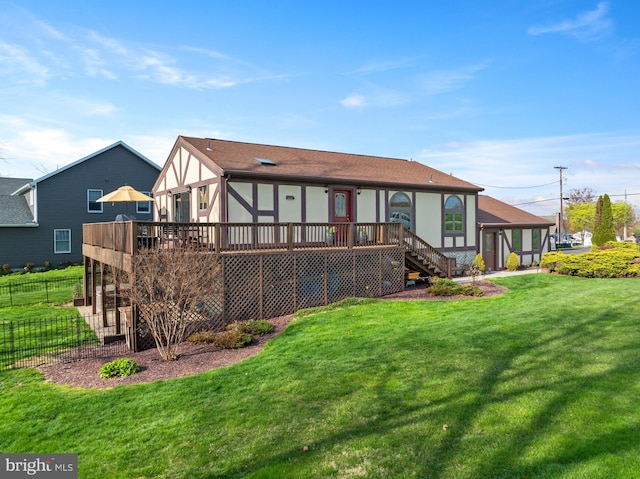 back of house featuring a yard, fence, a deck, and stairs