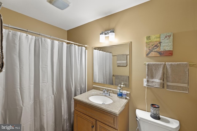 bathroom featuring visible vents, toilet, vanity, and a shower with curtain