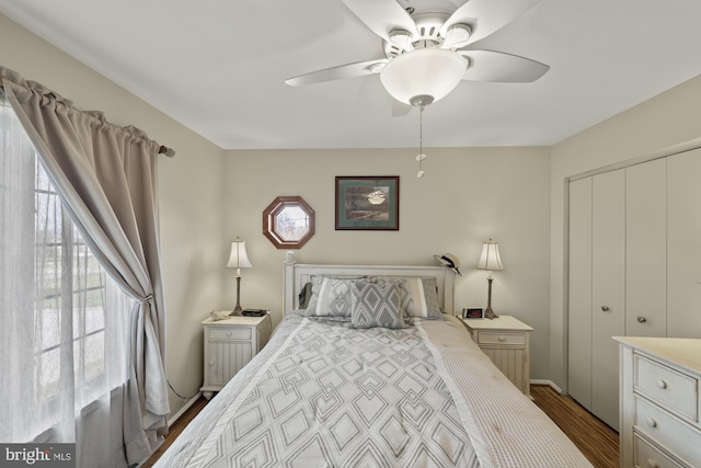 bedroom featuring a closet, baseboards, a ceiling fan, and wood finished floors