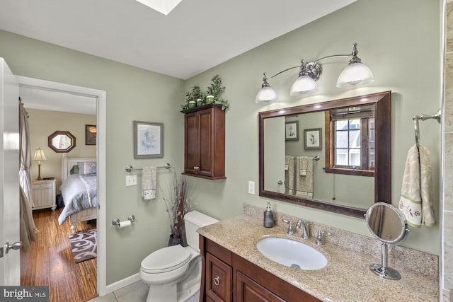 bathroom with vanity, baseboards, connected bathroom, and toilet