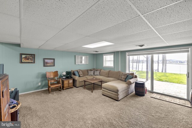 living room featuring baseboards, a drop ceiling, a water view, and carpet floors