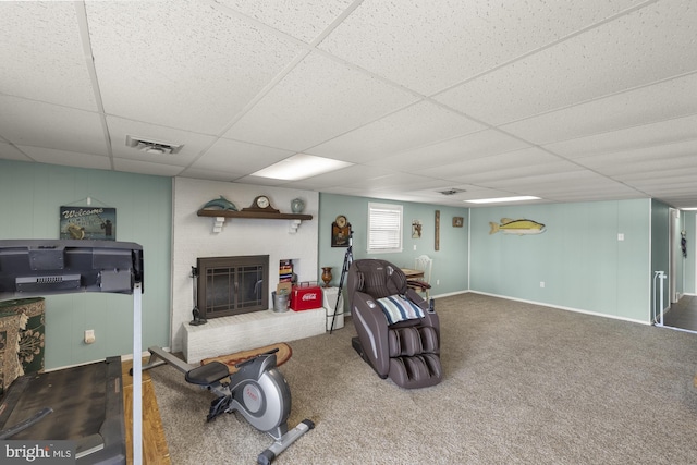 interior space with a paneled ceiling, a brick fireplace, and visible vents