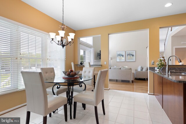 dining area with baseboards, recessed lighting, light tile patterned floors, and an inviting chandelier