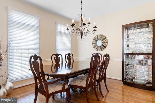dining space featuring a notable chandelier, baseboards, and light wood-type flooring