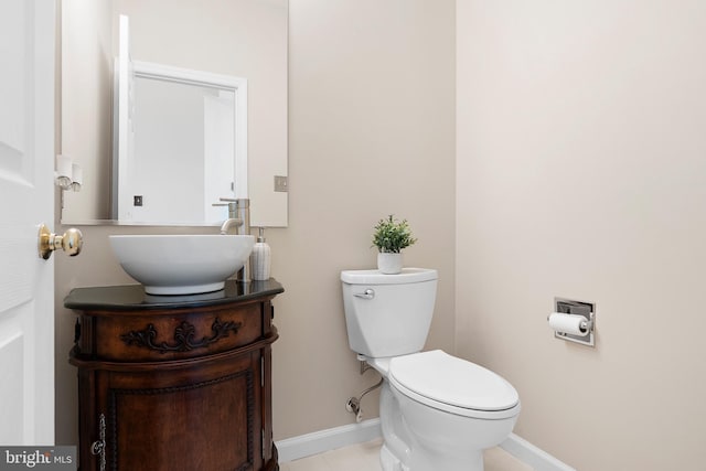 bathroom with toilet, tile patterned floors, vanity, and baseboards