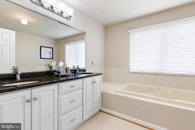 full bath featuring a garden tub, a sink, and a healthy amount of sunlight