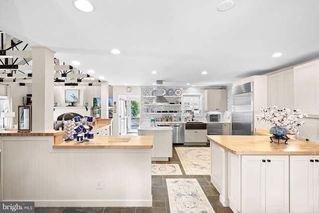 36437 Whispering Springs Ct, Purcellville, VA 20132 - kitchen featuring butcher block counters, appliances with stainless steel finishes, wall chimney range hood, a peninsula, and backsplash