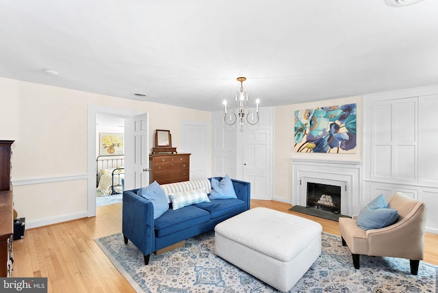 36437 Whispering Springs Ct, Purcellville, VA 20132 - living room with light wood-style floors, a chandelier, baseboards, and a fireplace