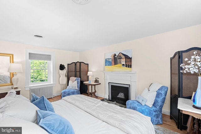 36437 Whispering Springs Ct, Purcellville, VA 20132 - bedroom featuring radiator, light wood-style floors, a fireplace with flush hearth, and baseboards