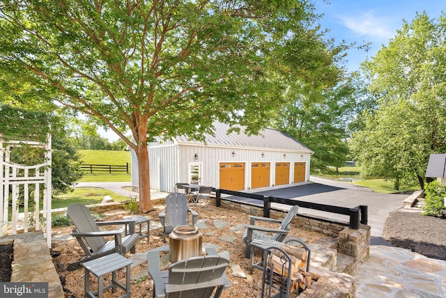 36437 Whispering Springs Ct, Purcellville, VA 20132 - view of patio / terrace featuring an outdoor fire pit and an outbuilding
