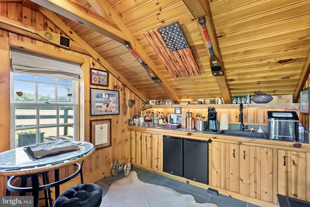 36437 Whispering Springs Ct, Purcellville, VA 20132 - kitchen with wooden ceiling, wooden walls, light brown cabinetry, a sink, and light tile patterned floors