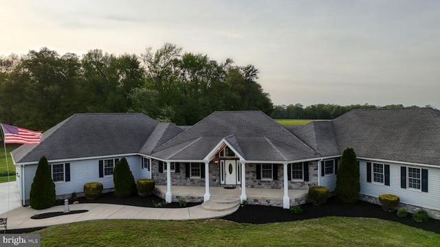 1081 Caldwell Corner Rd, Townsend, DE 19734 - single story home with a front yard, stone siding, roof with shingles, concrete driveway, and a porch