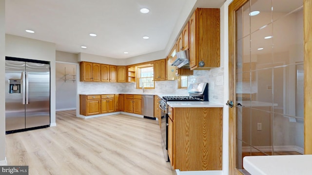 1081 Caldwell Corner Rd, Townsend, DE 19734 - kitchen featuring brown cabinetry, range hood, light wood-type flooring, light countertops, and stainless steel appliances
