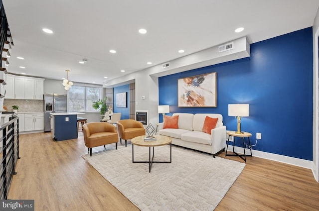 living room with baseboards, recessed lighting, visible vents, and light wood-style flooring
