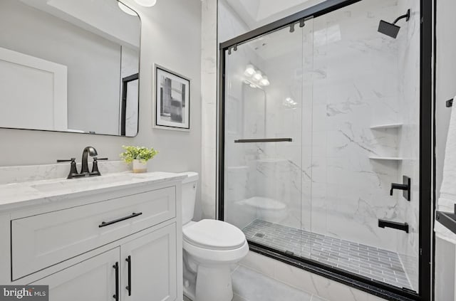 bathroom with toilet, vanity, and a marble finish shower