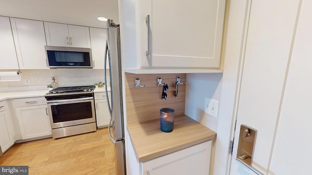 50 Florida Ave NE Unit 412, Washington, DC 20002 - kitchen with light wood finished floors, white cabinetry, appliances with stainless steel finishes, and tasteful backsplash