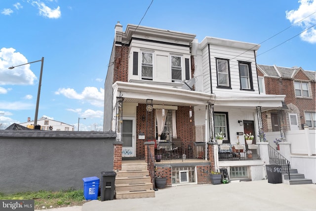 multi unit property featuring brick siding and covered porch