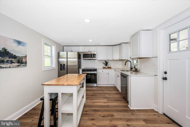 713 3rd St, Martinsburg, WV 25404 - kitchen featuring white cabinets, a sink, appliances with stainless steel finishes, butcher block counters, and decorative backsplash