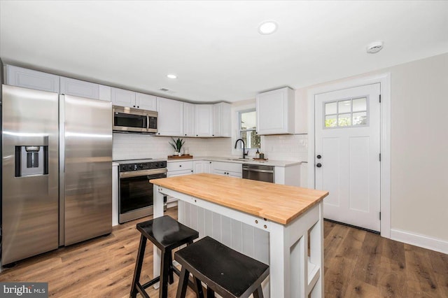 713 3rd St, Martinsburg, WV 25404 - kitchen with stainless steel appliances, tasteful backsplash, butcher block counters, and white cabinetry