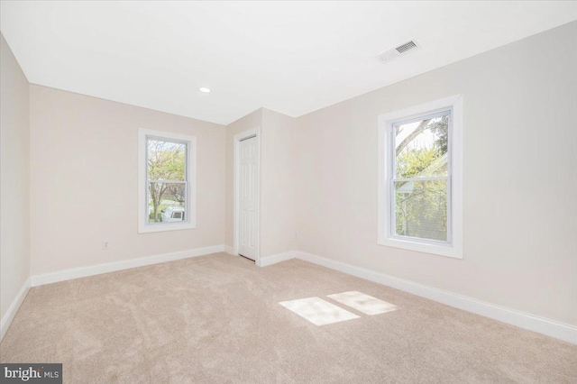 713 3rd St, Martinsburg, WV 25404 - unfurnished bedroom featuring visible vents, baseboards, multiple windows, and light carpet