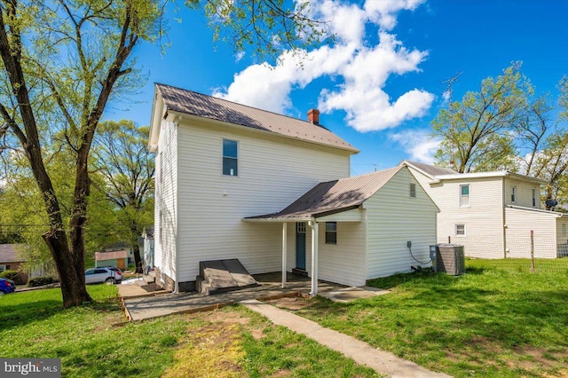 713 3rd St, Martinsburg, WV 25404 - back of house with central air condition unit, a patio, a yard, and a chimney